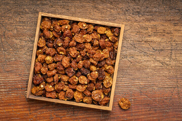 dried goldenberries in a square wooden box against rustic wood