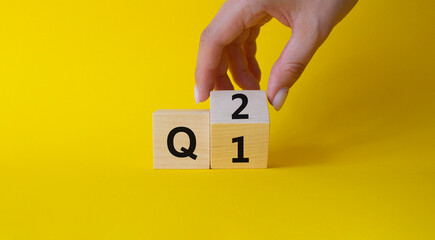 From 1st Quarter to 2nd symbol. Businessman hand Turnes cube and changes words 1st Quarter to 2nd Quarter. Beautiful yellow background. Business and Quarter concept. Copy space