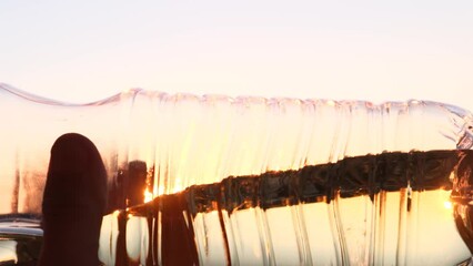 Sunflower oil in a plastic bottle against the sky, close-up - Powered by Adobe