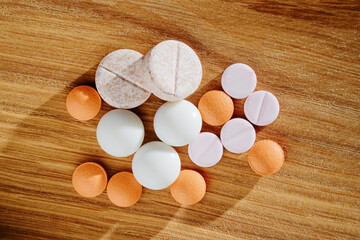 Fototapeta na wymiar Natural pharmacy drug concept. Bunch of different pills laying on wood background.