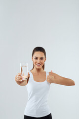 Portrait of beautiful woman on isolated studio background, hold water glass. Drink water. Diet...
