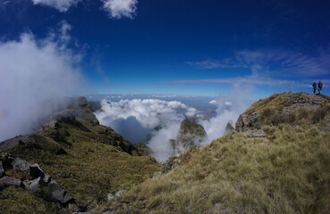 Panoramic view of valley landscape with clouds and a hiker and scout in the distance in the Simien Mountains Ethiopia, Africa