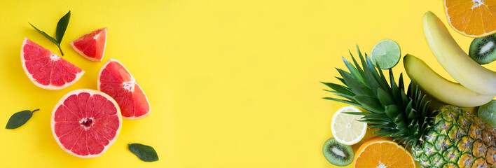Tropical fruits on the yellow background. Banner. Copy space. Top view.