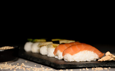 Different types of nigiri's sushi plated in blackboard