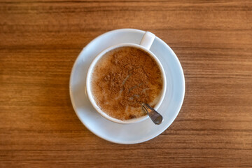 A cup of Salep on wooden table in a cafe.