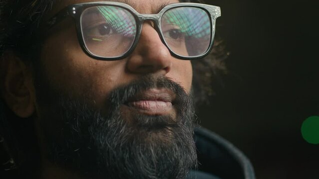 Thoughtful serious Indian businessman in eyeglasses looking away lost in thoughts thinking. Close up focused pensive bearded Arabian man with lights green reflection in glasses. Business vision idea