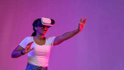 Cheerful Black Female Experiencing Virtual Reality In Vr Glasses Under Neon Lighting