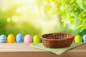 Empty basket with tablecloth and Easter eggs on wooden table over green bokeh background. Easter mock up for design and product display.