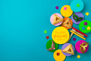 Purim carnival creative concept with carnival mask and traditional cookies on colorful podiums over blue background. Top view, flat lay