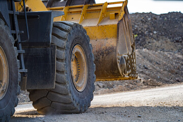 A front end loader machine tipping sand in a quarry