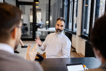 A candidate on senior developer position is sitting at the office on a job interview and talking to...