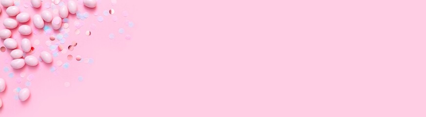 Bunch of candy eggs on pink background. Minimal Easter concept with copy space for text. Festive day backdrop. Flat lay style with minimalistic design.