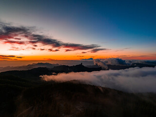 Magical sunset above the clouds with Teide volcano on the horizon. Sunset cinematic view from the top of Gran Canaria Island Pico de las Nieves point.