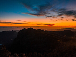 Magical sunset above the clouds with Teide volcano on the horizon. Sunset cinematic view from the top of Gran Canaria Island Pico de las Nieves point.