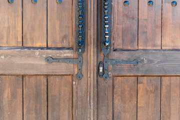 Fototapeta na wymiar Old, faded classical, brown, wooden door with iron door handle. Door textures and background.