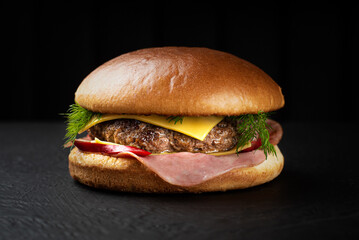Potato cheeseburger, with a spicy filling, with cheese on a black background, looks very appetizing