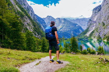Fototapeta na wymiar Man is hiking at Obersee am Königssee. beautiful Bavarian Landscape Behind and between the Königsee and Obersee