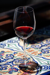 Copa con vino tinto sobre azulejos típicos españoles