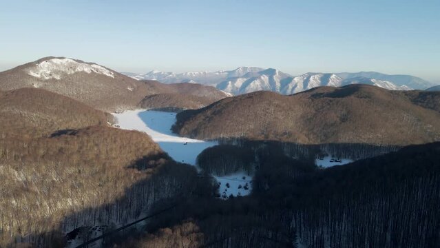 Aerial view of Verteglia Plateau with snow in wintertime at sunset on Mount Terminio, Serino, Avellino, Irpinia, Campania, Italy.