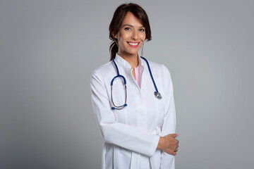 Studio portrait of middle aged female doctor against isolated background