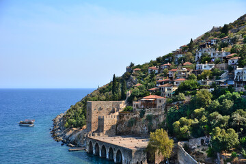 Fototapeta na wymiar coastline with ancient fortress and residential buildings with mediterranean sea and clear sky