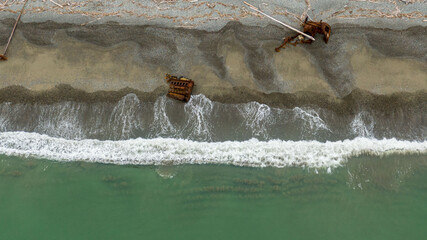 waves top view , old rusty spare part on the seashore. ecology