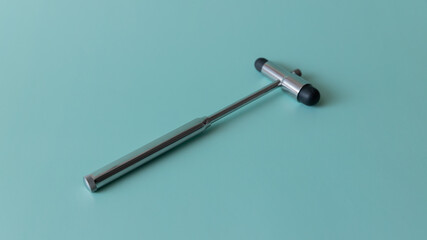 neurological hammer on a blue background. medical instrument on a turquoise background, medical equipment lies.