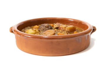 Lentil stew with chorizo, served in a clay bowl. Isolated on white background. Spanish food concept.