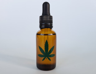 Marijuana oil extract and dried leaves on white background