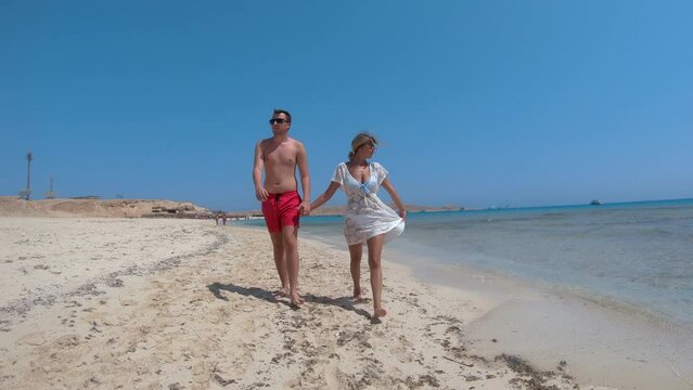 Couple on honeymoon walk on Paradise beach island in Hurghada, Egypt