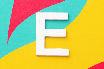 Letter E of the alphabet on colored background, top view