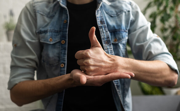 Sign language interpreter man translating a meeting to ASL, American Sign Language. Empty copy space for Editor's content
