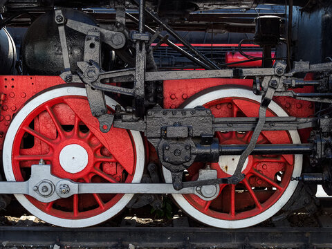 two huge metal wheels of an old steam locomotive