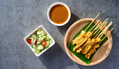 thai satay skewers with grilled pork and dipping sauces served on banana leaf plate