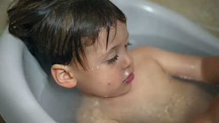 Small boy inside bath tub. Closeup baby tdodler bathing in bathtub washing body hygiene infant...