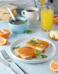 Sandwiches with marmalade, orange juice and coffee ready for breakfast	