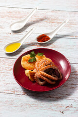 Dish of octopus seasoned with potatoes, olive oil and sweet and spicy paprika.