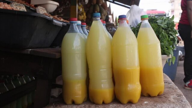 Closeup of plastic bottles with manioc tucupi sauce, yellow broth extracted from cassava at a street fair in Manaus, Amazonas, Brazil. Concept of food, cooking, ingredient, exotic, traditional.