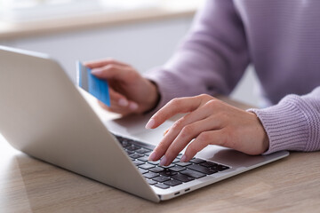 Woman holding credit card and using laptop computer, Businesswoman working at home, Online shopping, e-commerce, internet banking, spending money, working remotely