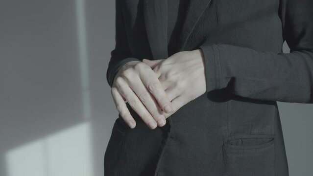 Hands at the level of the abdomen during a conversation. Minor finger movements. Emotional gesture.