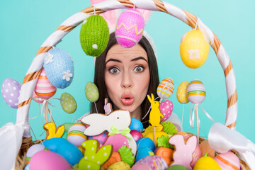 Photo of pretty impressed woman wear striped sweater bunny headband holding colorful eggs isolated...