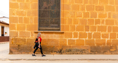 beautiful blonde woman traveling through towns and making stops on the road enjoying the trip walking through old streets