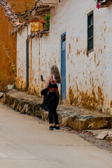 Fototapeta na wymiar beautiful blonde woman traveling through towns and making stops on the road enjoying the trip walking through old streets