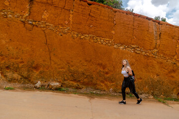 beautiful blonde woman traveling through towns and making stops on the road enjoying the trip walking through old streets