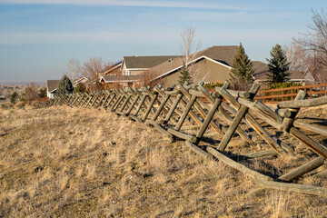 Fototapeta na wymiar wooden fence and dirt trail along a residential area at Colorado foothills