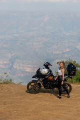 Obraz premium Beautiful blonde woman traveling by motorcycle through old towns walking and walking through its streets and mountains full of gardens enjoying the beautiful views and landscapes on vacation
