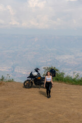 Beautiful blonde woman traveling by motorcycle through old towns walking and walking through its streets and mountains full of gardens enjoying the beautiful views and landscapes on vacation