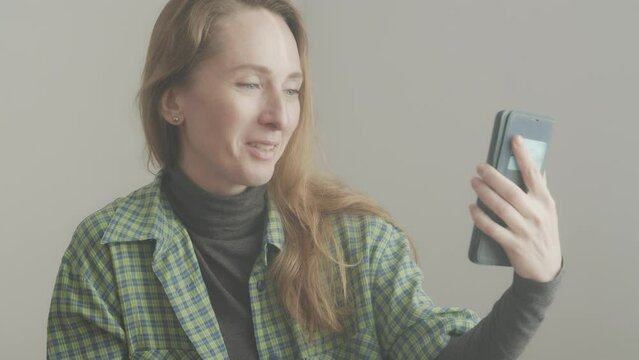 A woman is talking on a video link through a smartphone. Friendly dialogue.