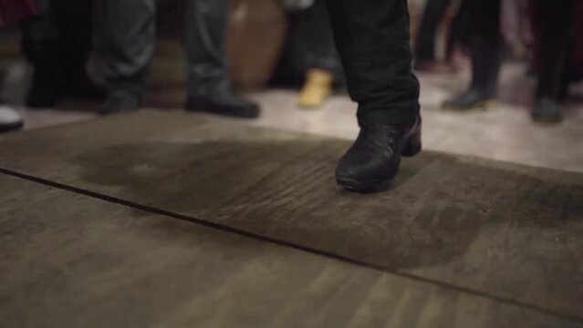 Close up of a tap dance teacher on a wood stage during a traditional folk jam session