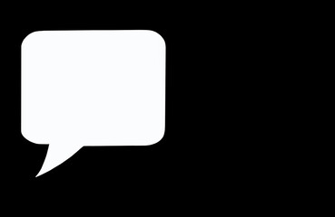 Paper white speech bubble on black background. Flat white chat icon in the form of an empty speech bubble. Free space for text or image. Internet communication concept. Digital communication sign
